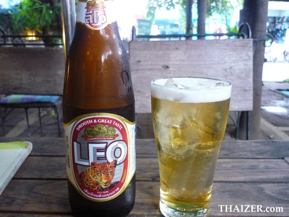 A bottle of leo beer next to a glass of leo beer with ice