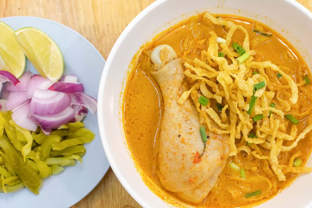 Khao Soi a famous northern Thai dish with chicken, noodles, curry, lime, red onions, and some vegetables