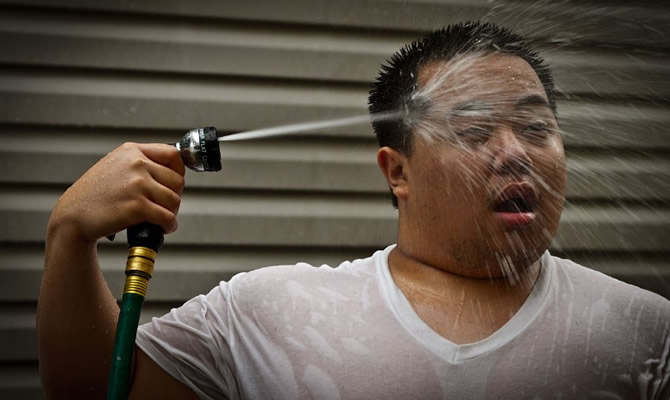 A man spraying himself to escape Thailand's heat