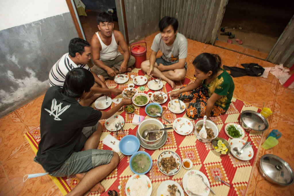 A family sitting on the floor eating a meal