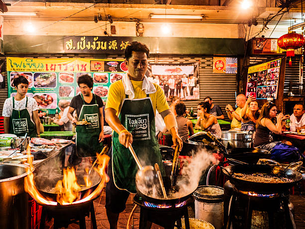 A man cooking street food in Chinatown, Bangkok Thailand.