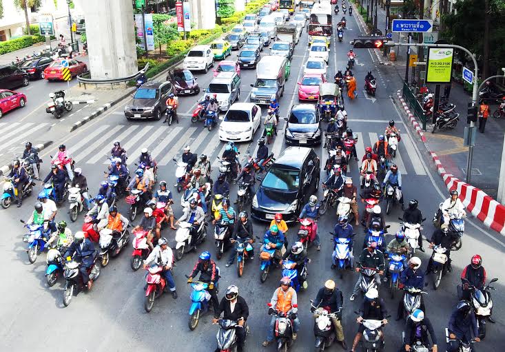 A chaotic scene with motorbikes and cars in Bangkok Thailand