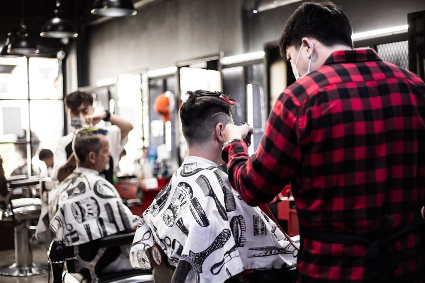 A thai barbershop showing some customers getting haircuts.