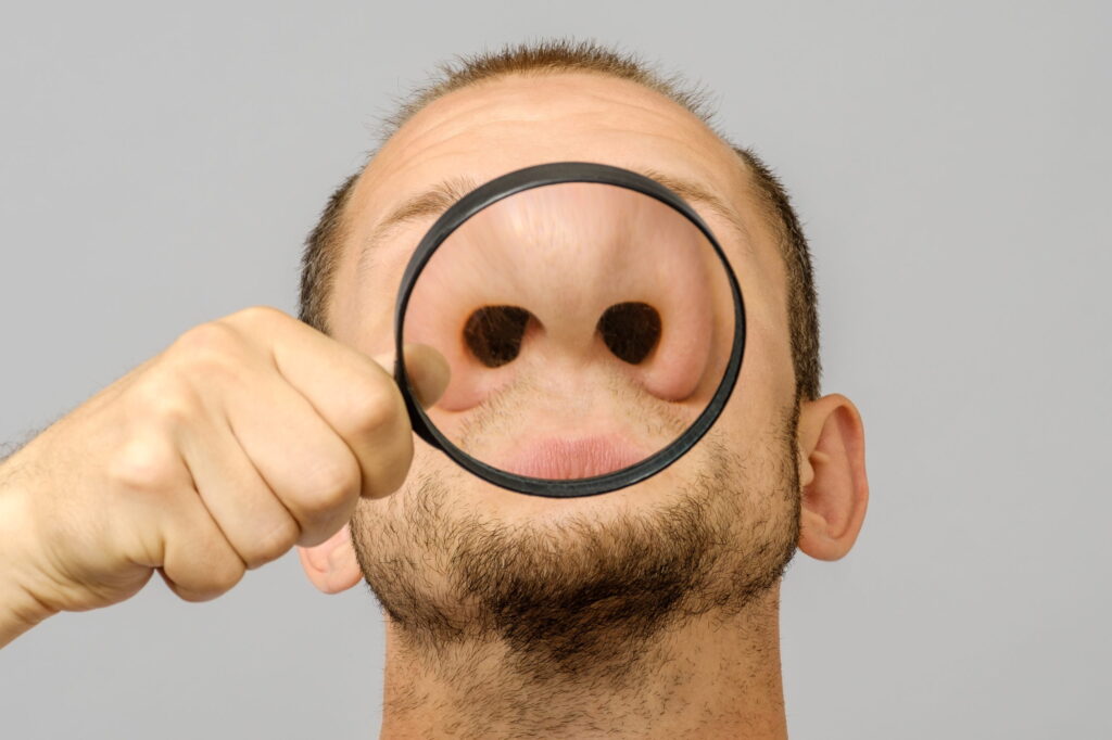 A man using his nose to smell if the street food is ok.